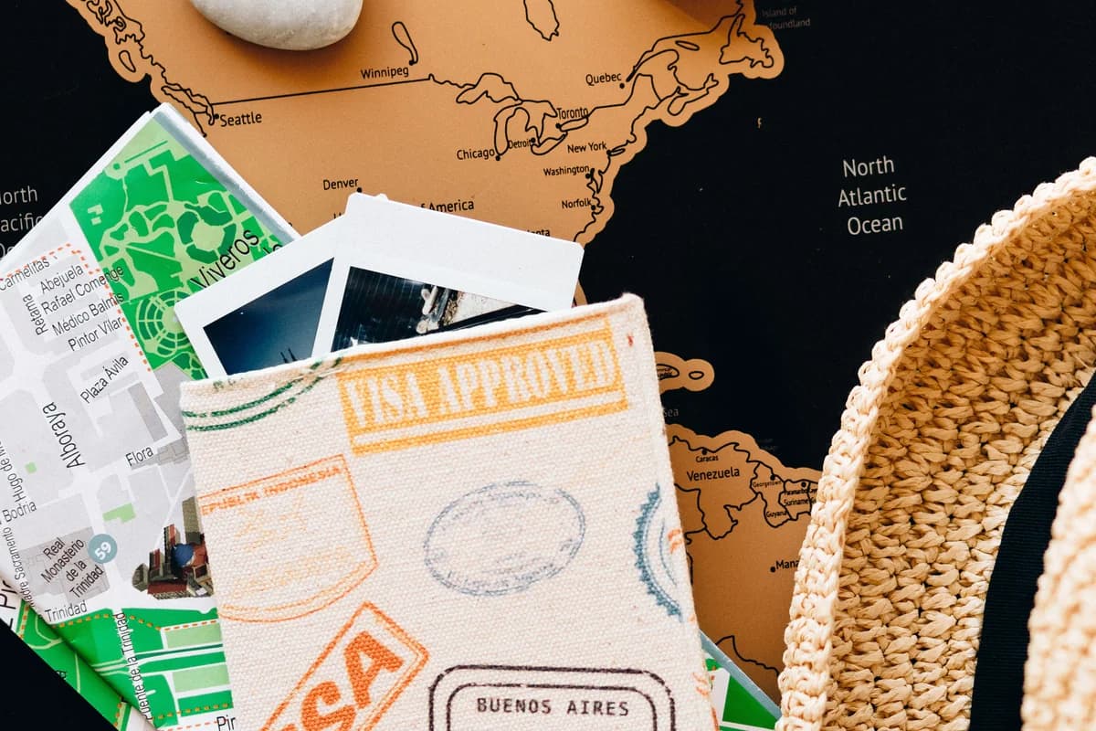 A passport and compass arranged on a world map for travel planning